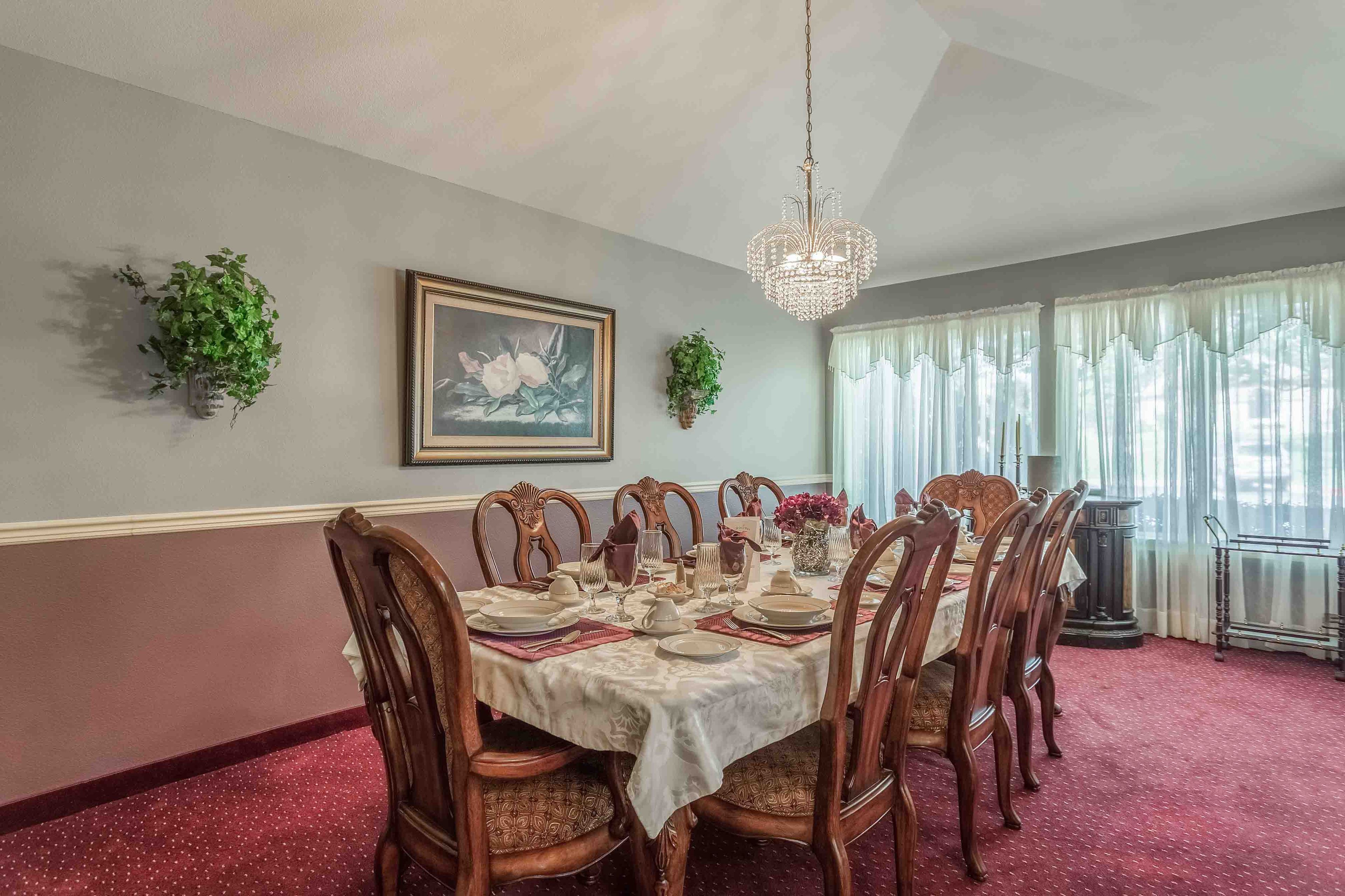 Senior living community, Gardens At Arkanshire, featuring elegant dining room with chandelier and decor.