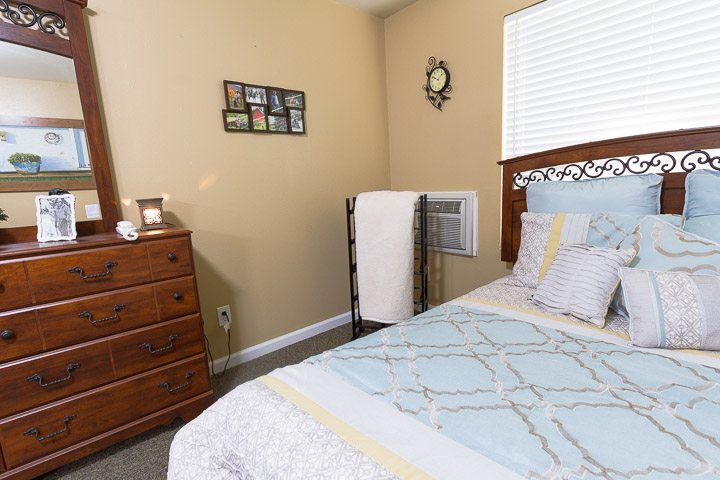 Senior living community bedroom at Aarenbrooke Place Cory Lane with stylish home decor.