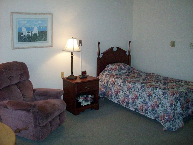 Senior living room at Christian Care Assisted Living with cozy furniture and bedroom setup.