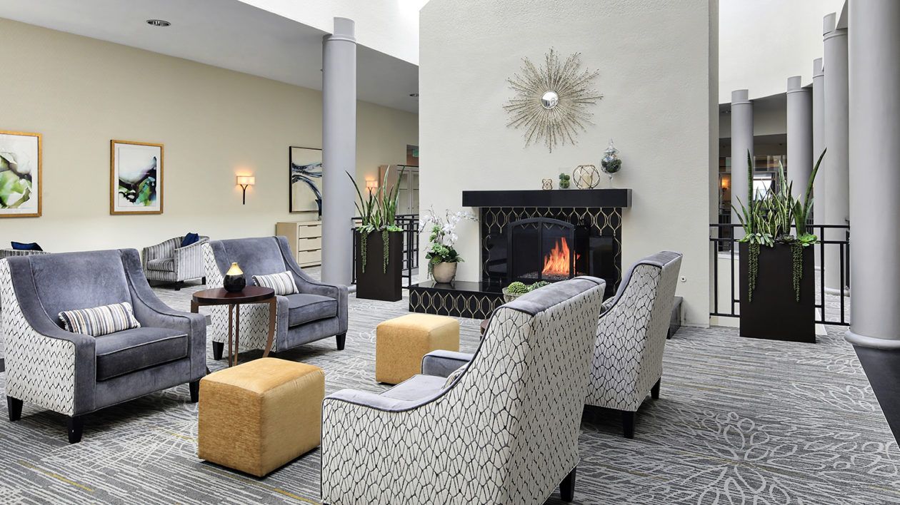 Senior living community, The Ivy at Wellington, featuring a cozy living room with fireplace and home decor.