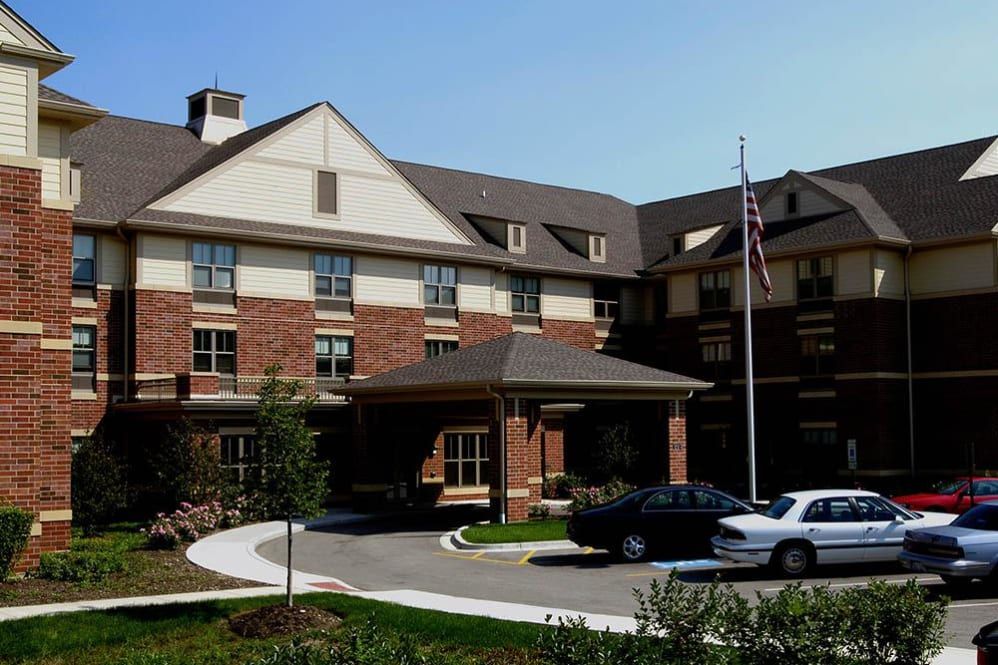 Senior living community, Alexian Village of Elk Grove, featuring housing architecture, vehicles, and residents.