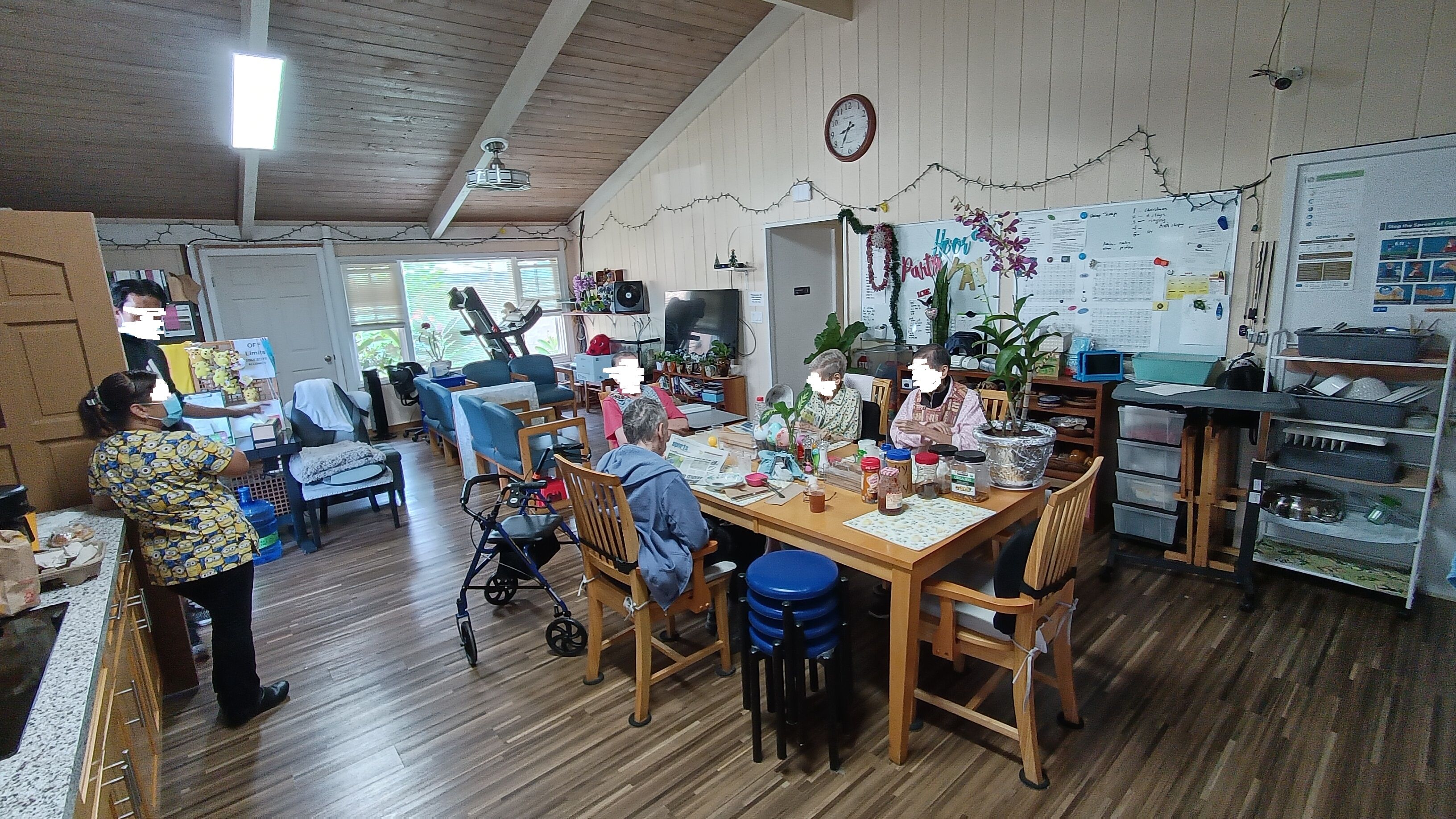Seniors enjoying communal dining in the stylish, hardwood-floored interior of AAA Care Home.
