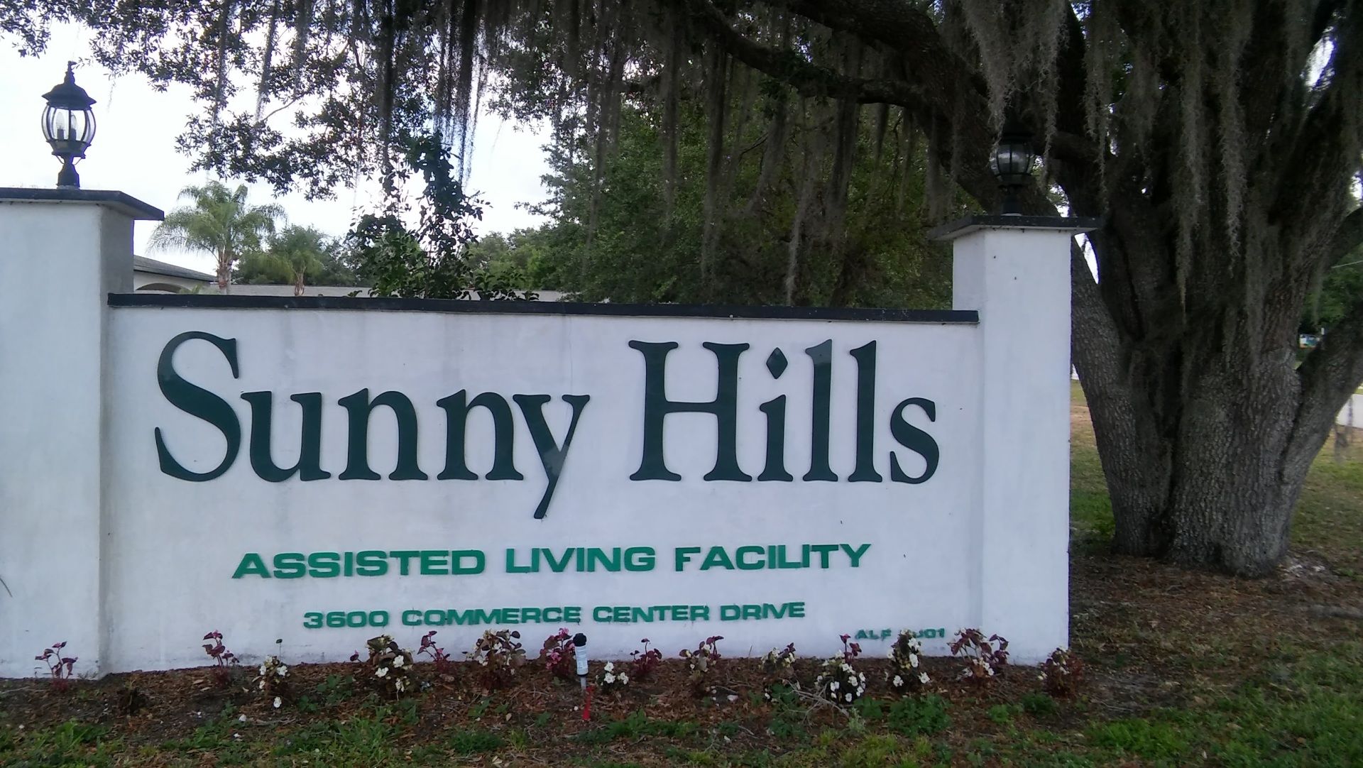 Sunny Hills of Sebring senior living community amidst lush park with various trees and wildlife.