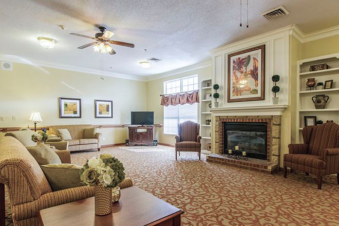 Interior view of Brookdale Falling Creek senior living room with modern decor, fireplace, and electronics.