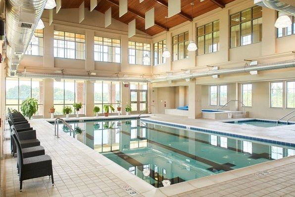 Senior residents enjoying at Wesley Willows resort with pool, hot tub, and lush greenery.