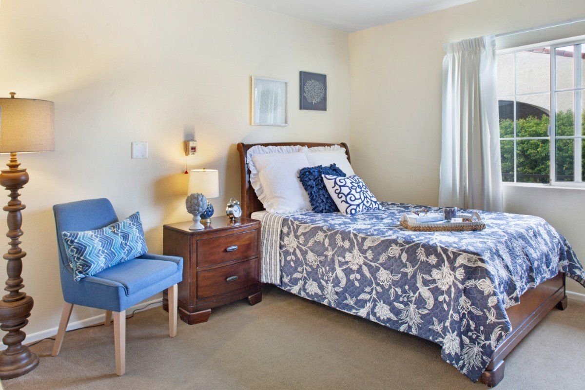 Senior living bedroom interior at Sunrise of Yorba Linda featuring cozy decor and furniture.