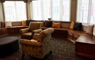 Senior living community reception area at Courtyard Estates Of Farmington with cozy furniture.