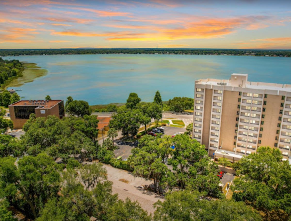 Scenic view of Lake Howard Heights senior living community with urban architecture and lakefront.