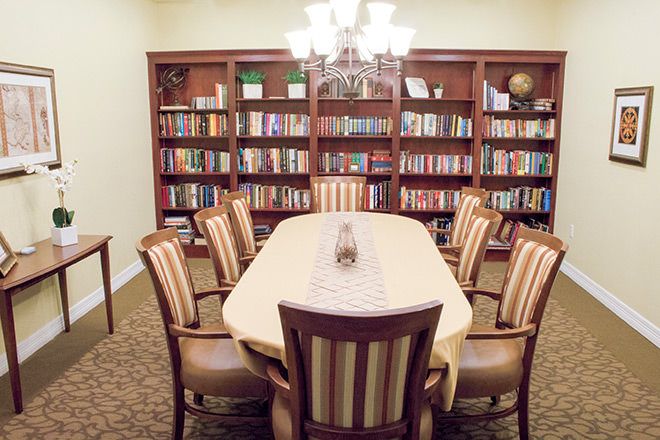 Interior view of Brookdale Round Rock senior living community featuring dining room, library, and furniture.