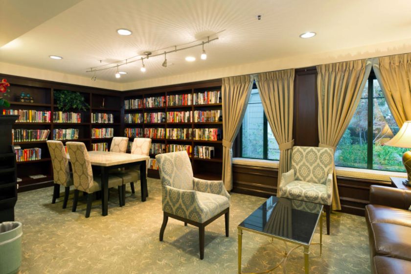 Interior view of Sterling Court senior living community featuring a library and dining area.