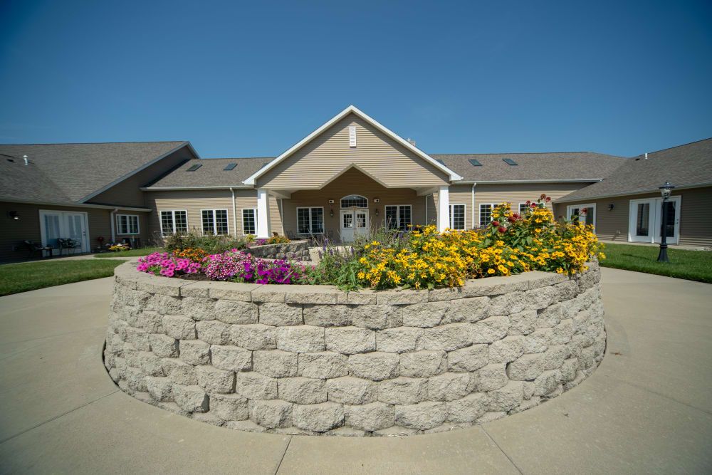 Senior living community, Villas Of Holly Brook Herrin, featuring lush greenery and beautiful architecture.