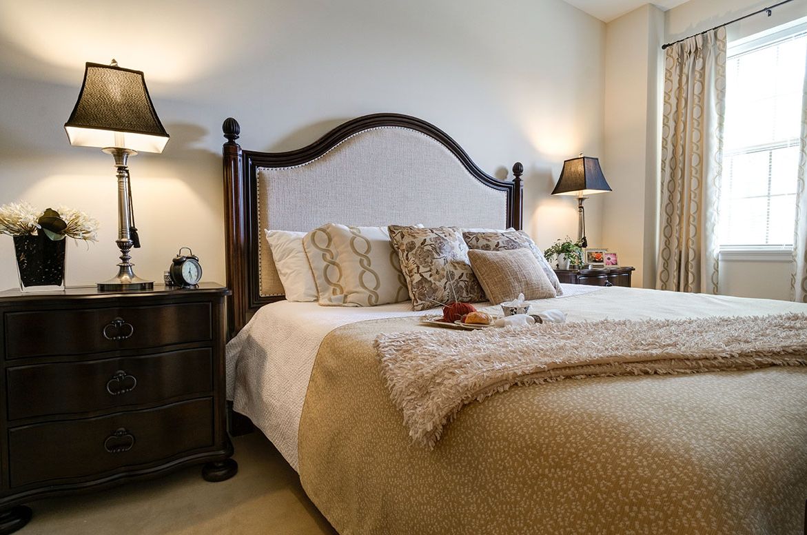 Interior view of a cozy bedroom at The Parc At Harbor View Senior Living with tasteful decor.