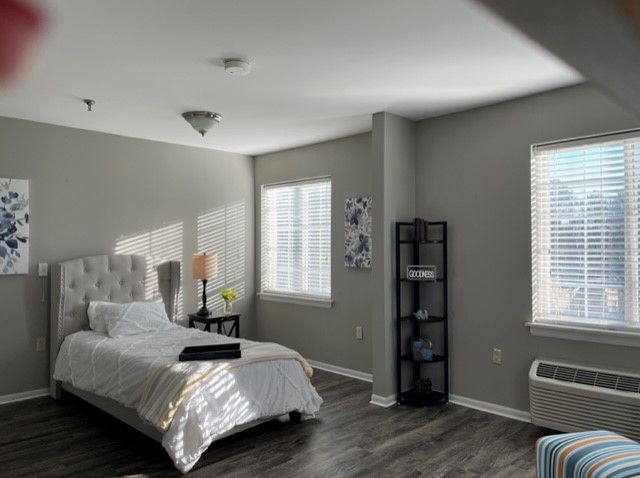 Corner view of a well-decorated bedroom with modern furniture at The Village at Primacy Place.