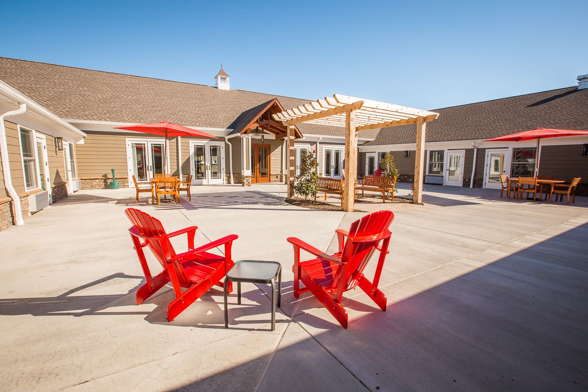 Senior living community house with patio furniture, indoor interior design, and outdoor pergola.