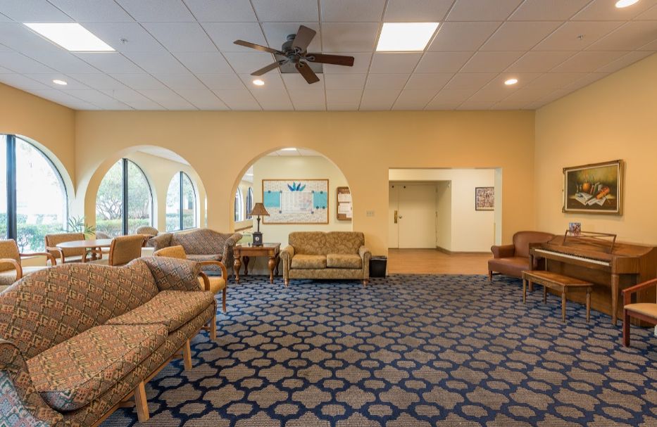 Interior view of Atlantis Assisted Living with modern decor, piano, and comfortable seating.