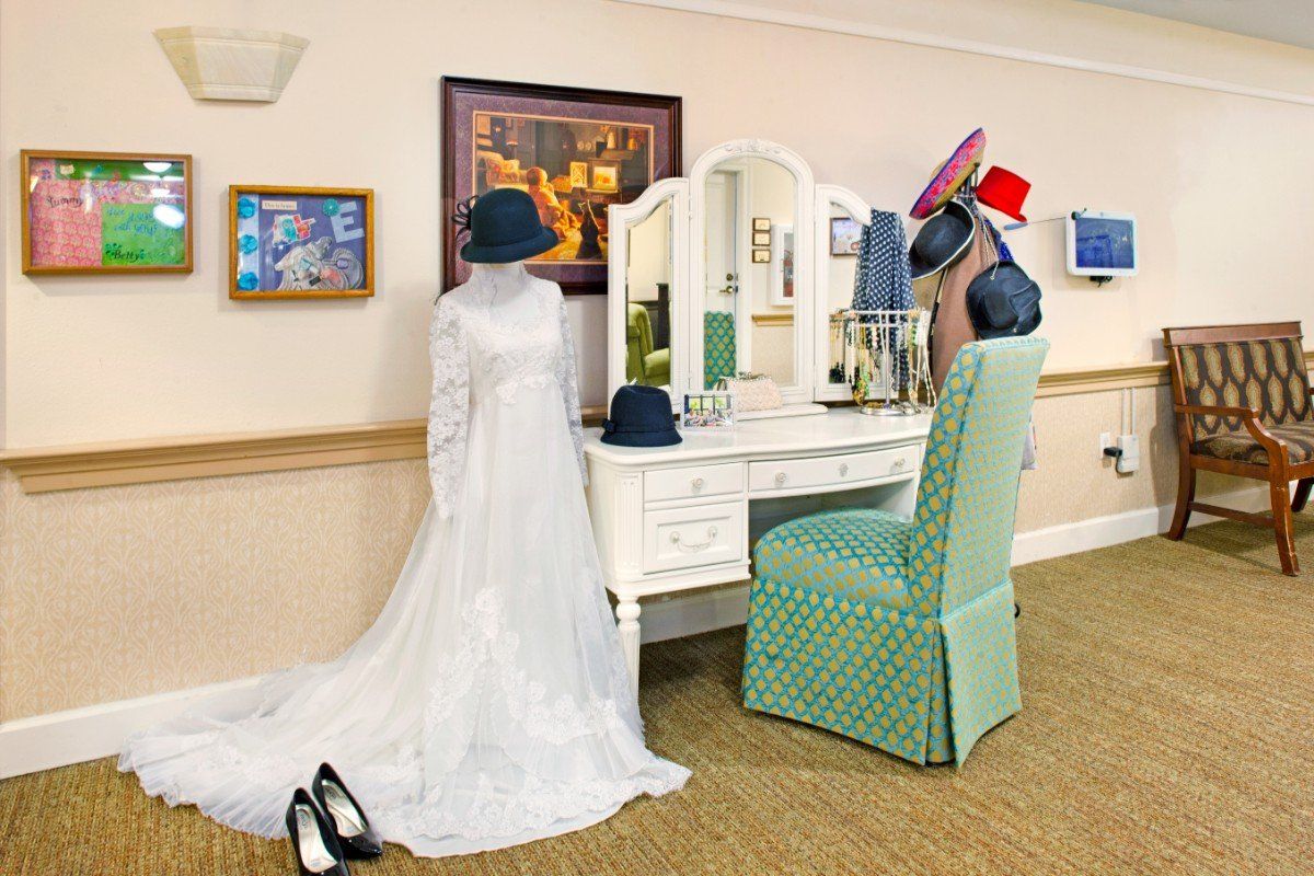 Bride in wedding gown in dressing room at Ivy Park at Alta Loma, surrounded by art and furniture.