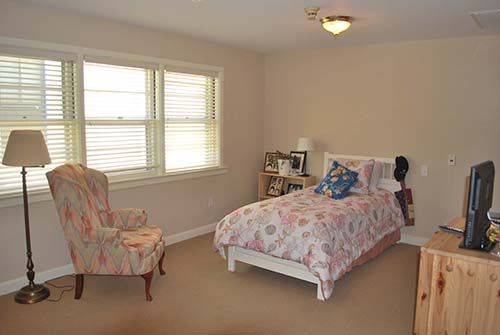 Senior living community bedroom at Canterbury Village with furniture, decor, and electronics.