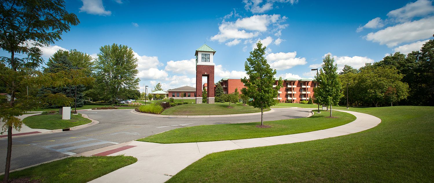 Architectural view of Samaritas Senior Living Grand Rapids - Lodge with clock tower and lush lawn.