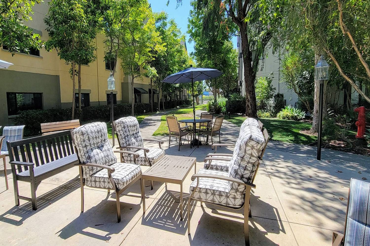 Senior living community at Westminster Terrace with outdoor patio, lush greenery, and city views.