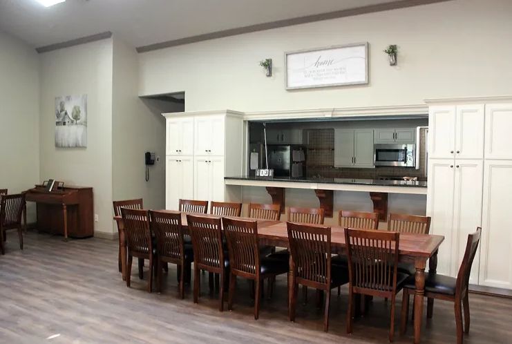 Interior view of Premier Assisted Living community featuring dining area, kitchen appliances, and decor.