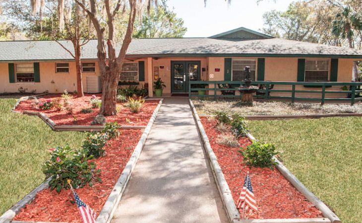 Architectural view of Haven House of Ocala, a resort-style senior living community with lush outdoors.