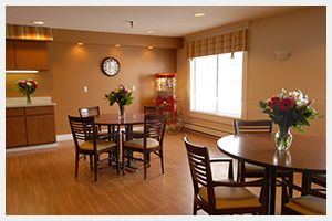 Interior view of Delta Retirement Center featuring hardwood floors, dining room with furniture, and flower arrangements.