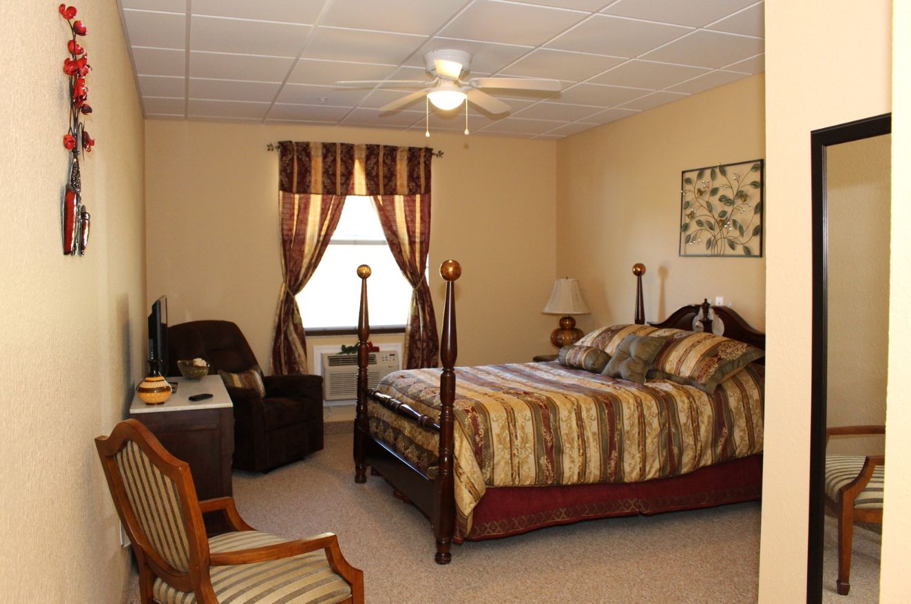 Interior view of a well-furnished bedroom at Marion Oaks Assisted Living with modern decor and appliances.