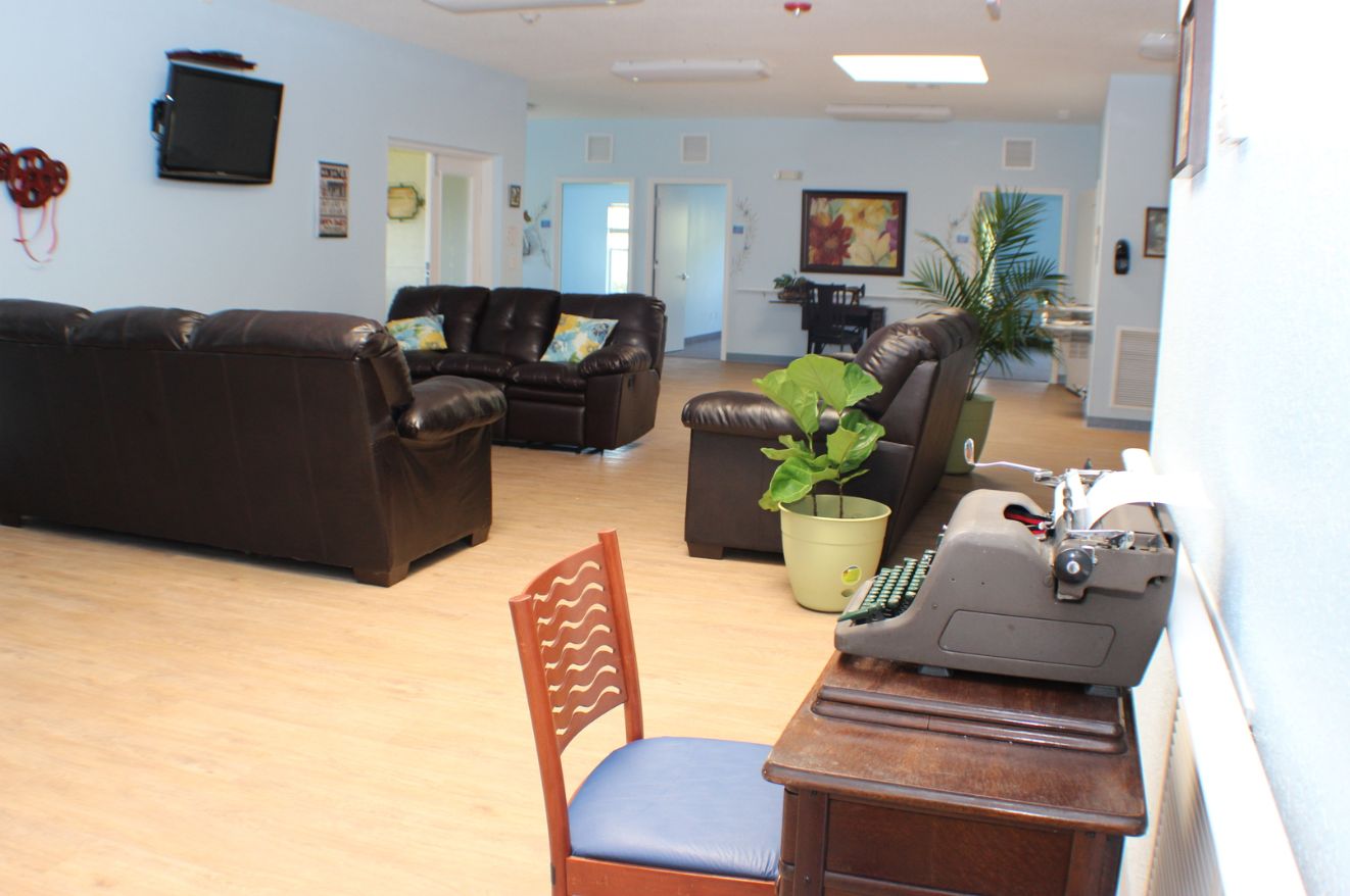 Interior view of Marion Oaks Assisted Living featuring modern furniture, hardwood floors, and electronics.