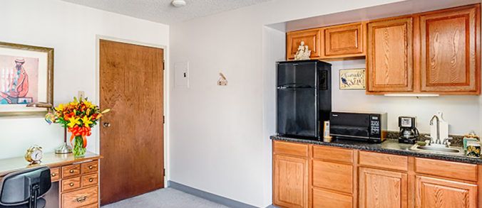 Interior view of Vista Montana Senior Living kitchen with modern appliances and wooden furniture.