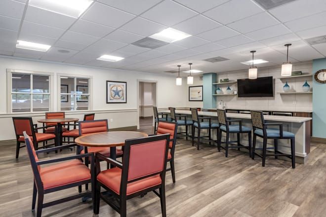 Interior view of Brookdale West Palm Beach senior living community featuring dining area, lounge, and art.