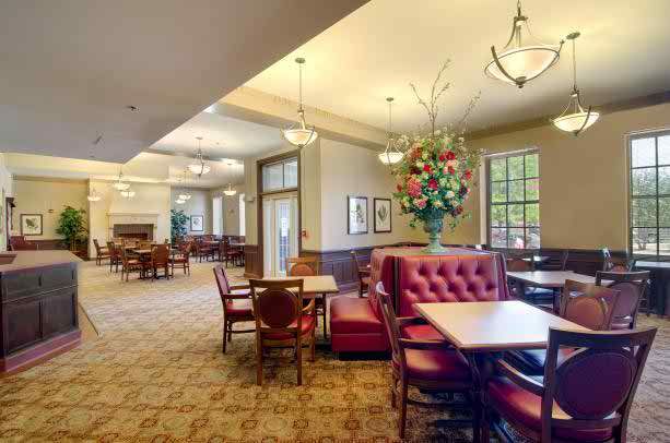 Interior view of Senior Suites Joliet featuring elegant dining room with chandelier and modern decor.