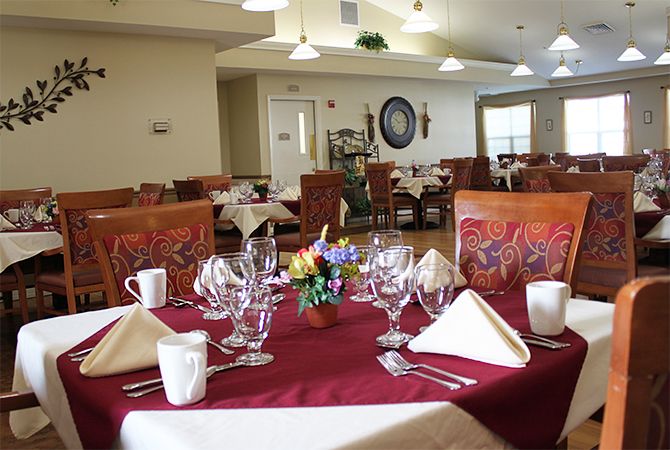 Senior living community dining room at Heron Place with elegant furniture and flower arrangements.