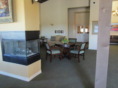 Interior view of Sunny Rose Glen senior living community featuring dining room, reception area, and living room.