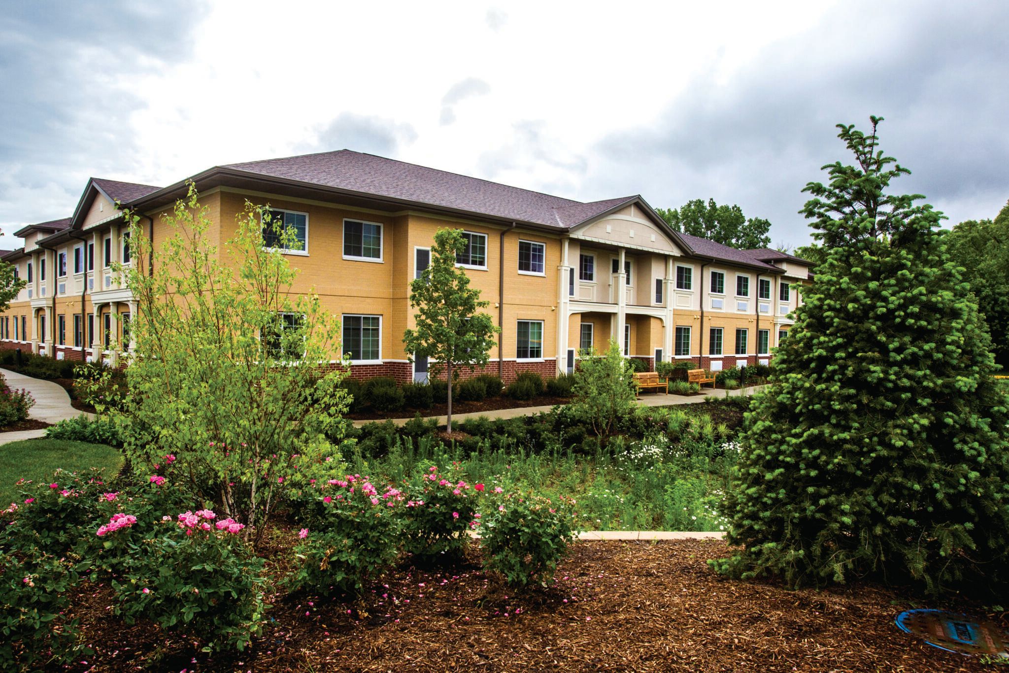 Senior living community, Cedar Lake Assisted Living and Memory Care, with lush greenery and urban architecture.