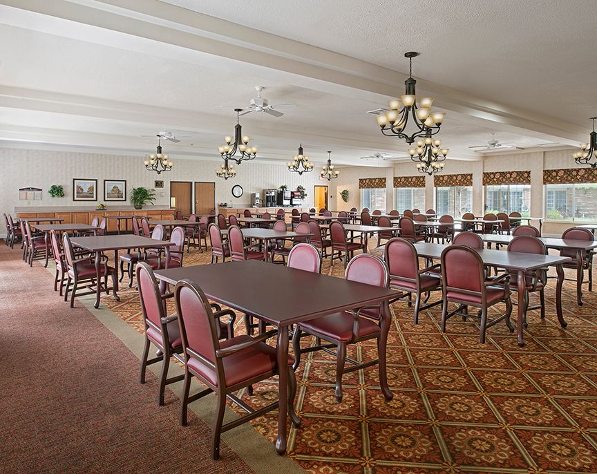 Interior view of American House Livonia senior living community featuring dining room and reception area.