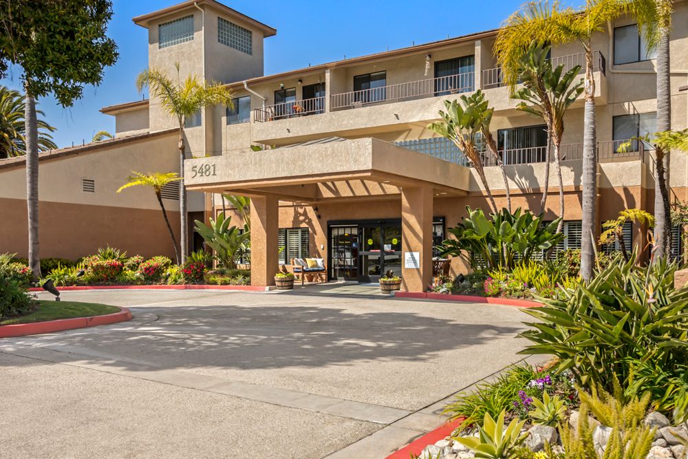 Summer view of Brookdale South Bay senior living community with urban architecture, fire station and vehicles.