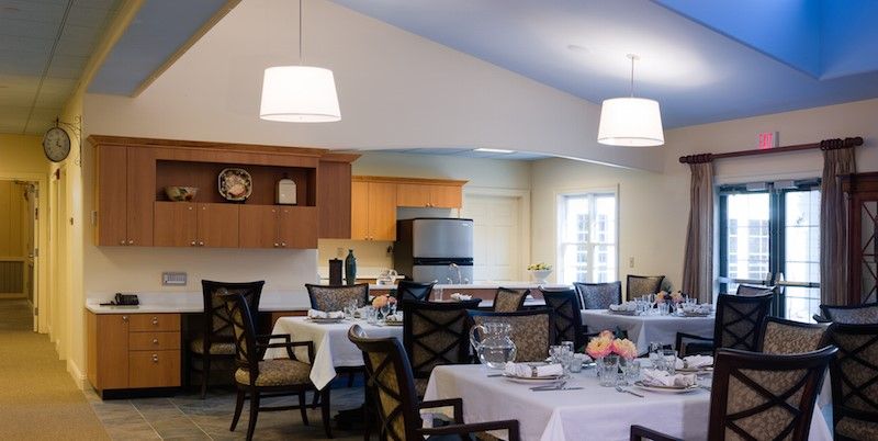 Senior living community interior at The Memory Center, Virginia Beach featuring dining and kitchen areas.