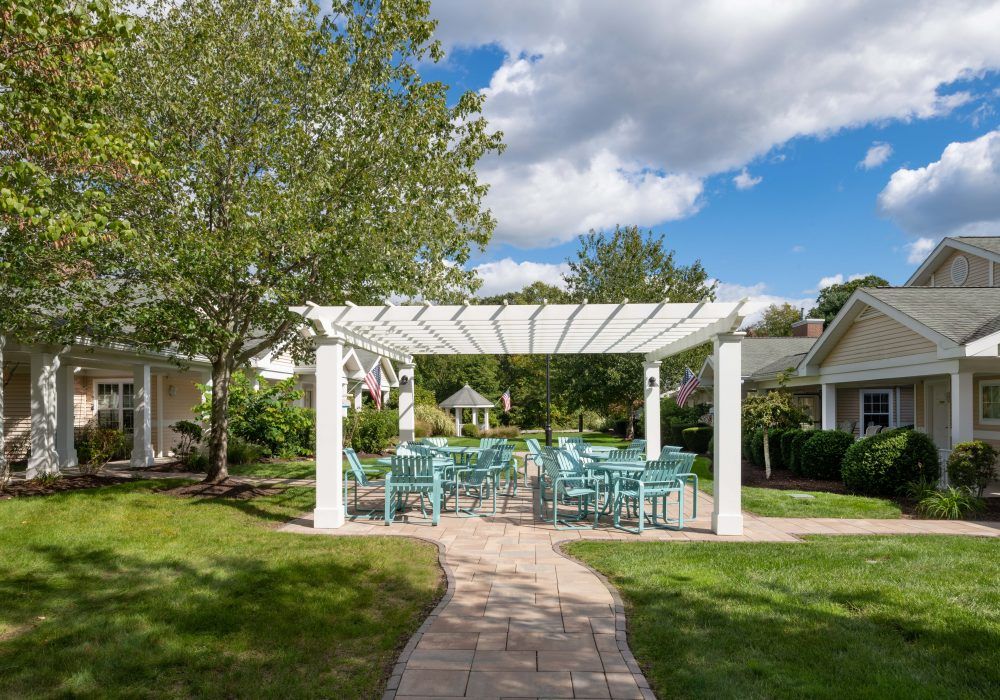Senior living community at The Cottages At Dartmouth Village with lush backyard and patio.