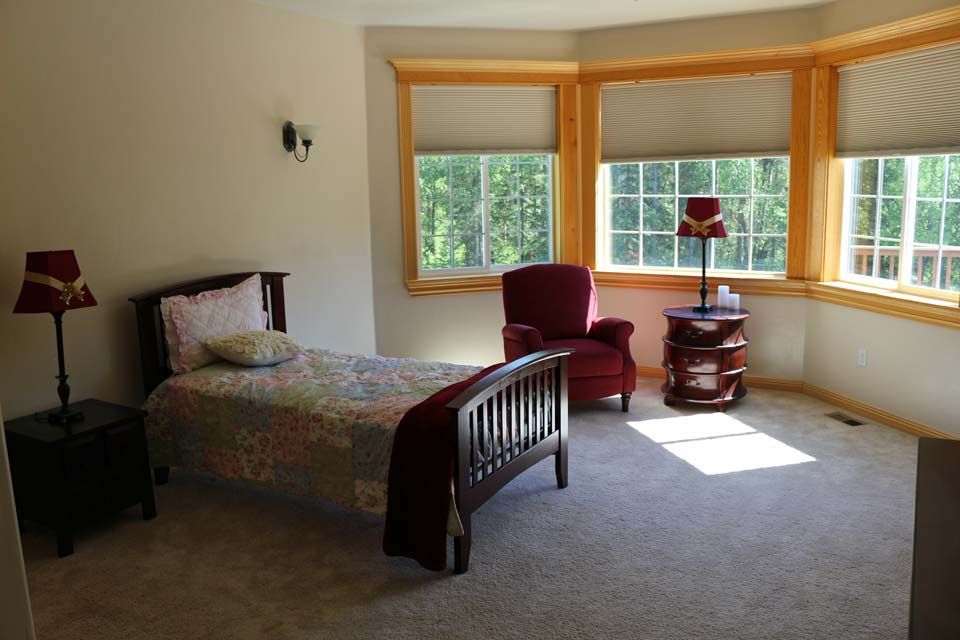 Bedroom interior at Joshua House senior living community featuring cozy decor and furniture.