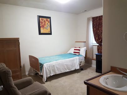 Interior view of Ark Of Caring Assisted Living Home featuring a furnished bedroom with sink.