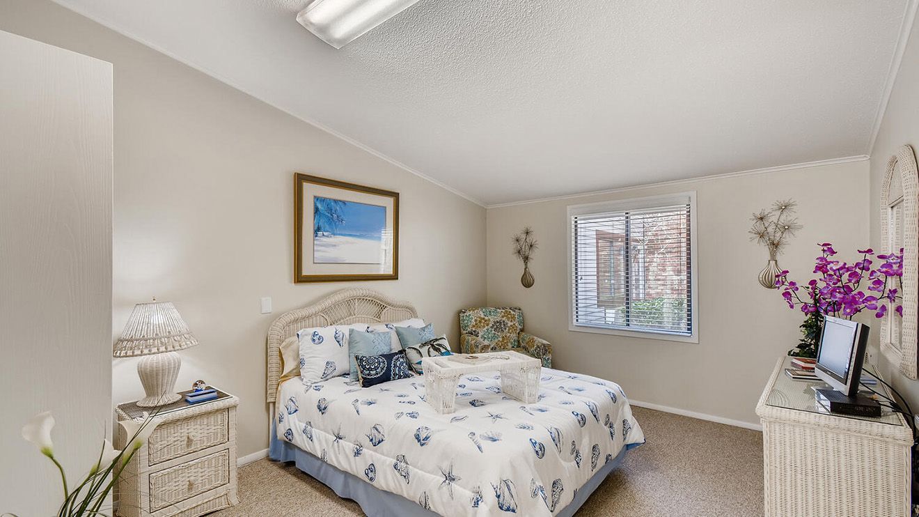 Interior design of a bedroom in Home Decor senior living community at Woodlands Village, featuring cozy furniture.