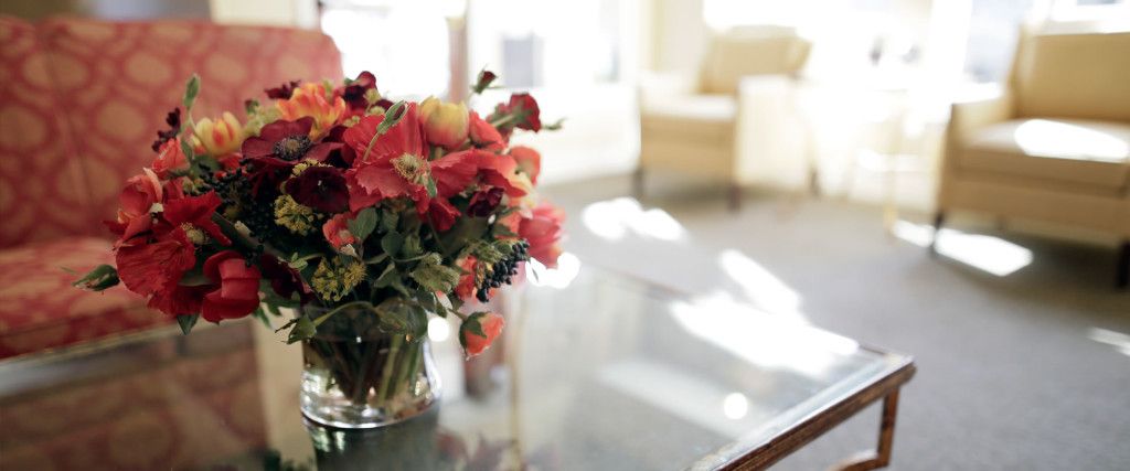 Senior living room at Highgate, Prescott Lakes with floral design, furniture, and art.