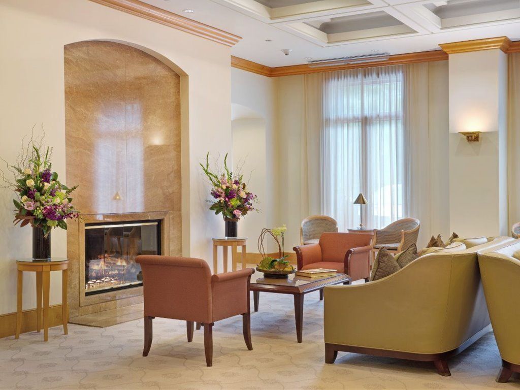 Interior view of The Stratford senior living community featuring elegant decor, fireplace, and furniture.