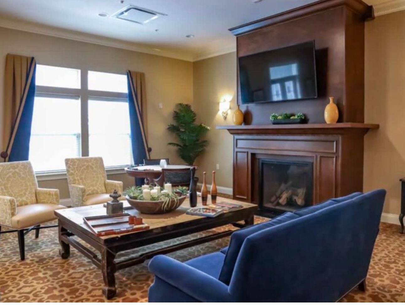 Interior view of Quincy Place Senior Living room with modern furniture, fireplace, and computer setup.