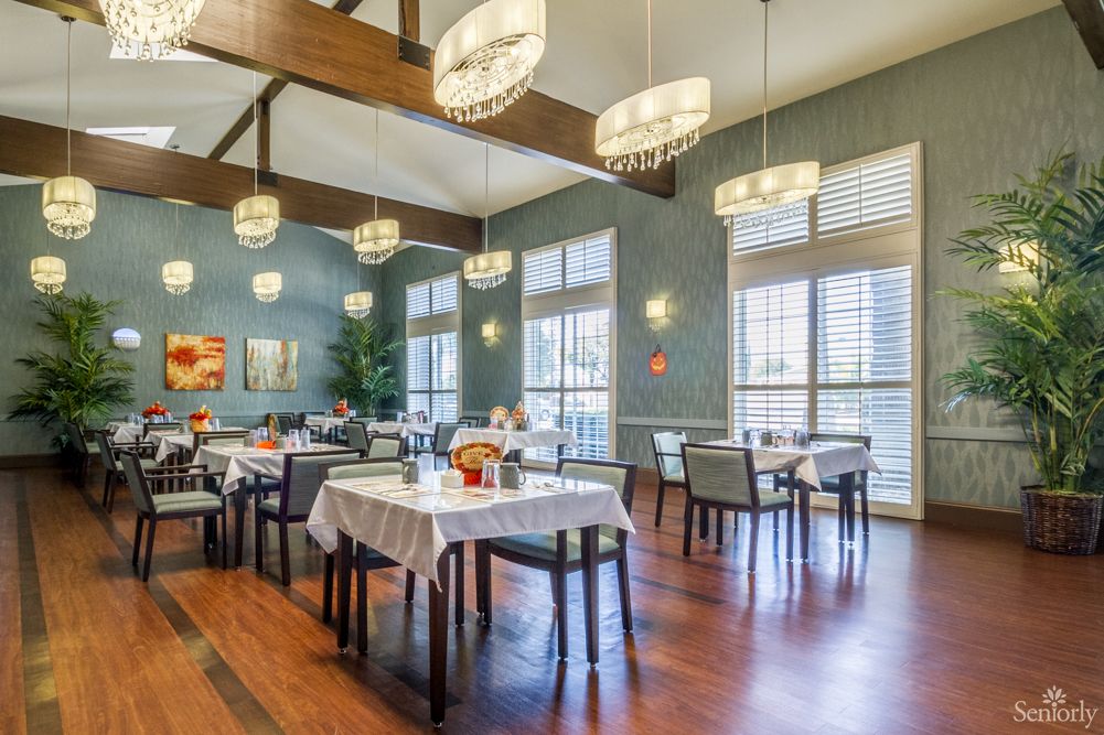 Interior view of Montclair Royale Senior Living featuring hardwood flooring, dining room with furniture, and home decor.