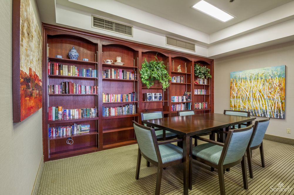 Interior view of Montclair Royale Senior Living featuring dining area, library, and art-filled rooms.