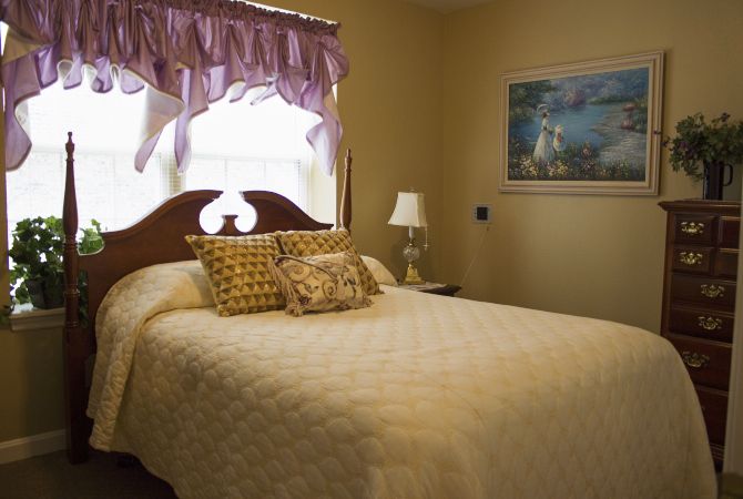 Interior view of a cozy bedroom at Marquis Gardens Place senior living community.