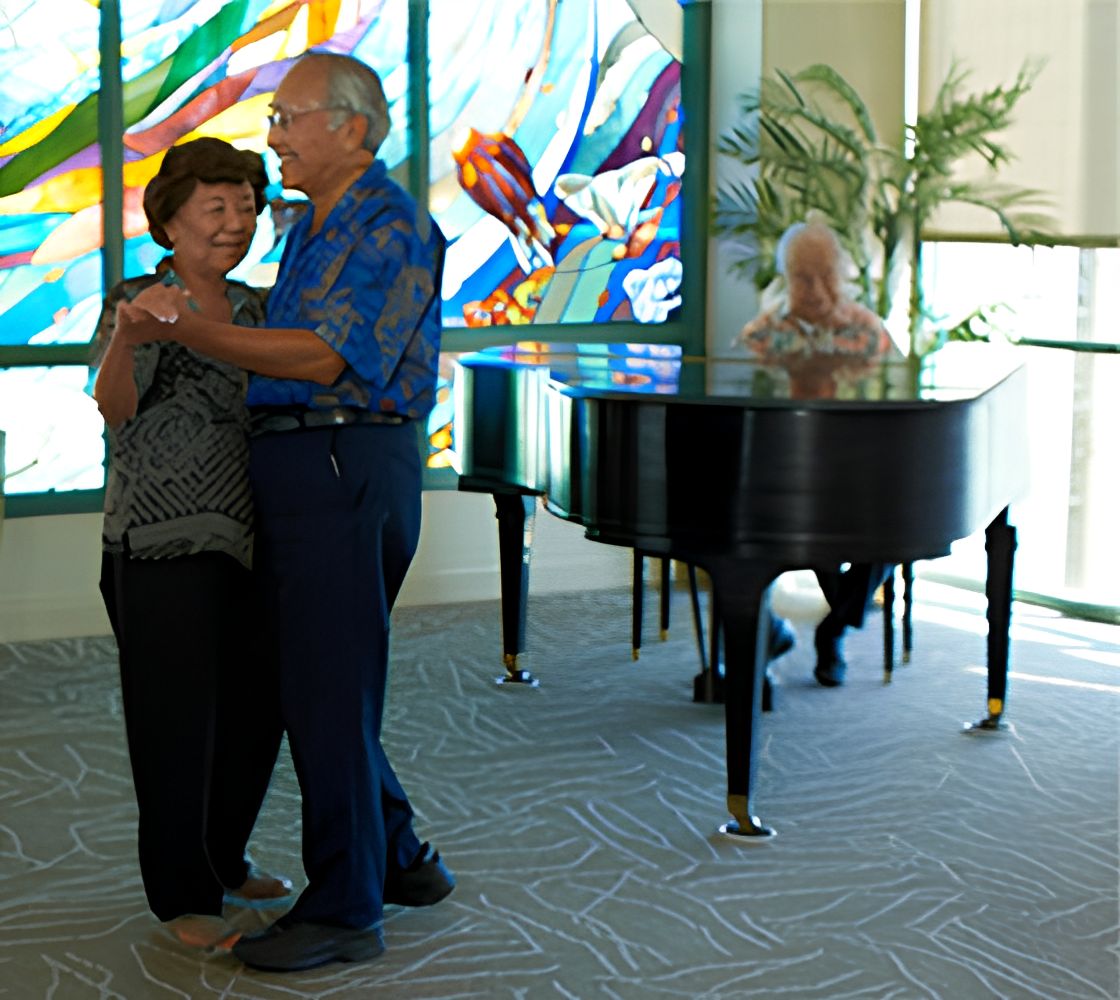 Senior man and woman playing grand piano and keyboard at 15 Craigside senior living community.