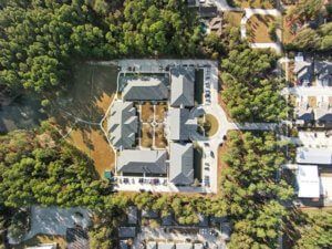 Aerial view of SummerHouse Park Provence, a senior living villa surrounded by lush woodland.