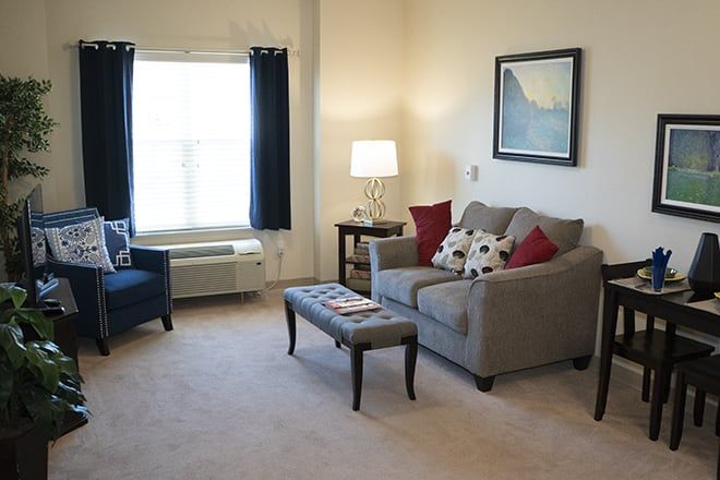 Senior living room at Brookdale Highlands featuring cozy furniture, art decor, and indoor plants.